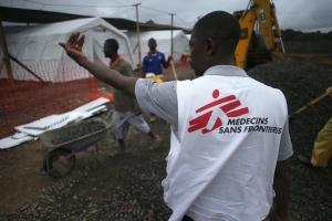 A Doctors Without Borders staffer supervises as construction workers complete the new Ebola treatment center on August 17, 2014 near Monrovia, Liberia.